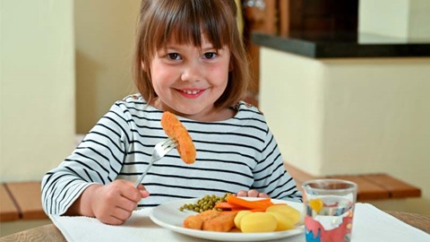 enfant mangeant des batonnets de poisson